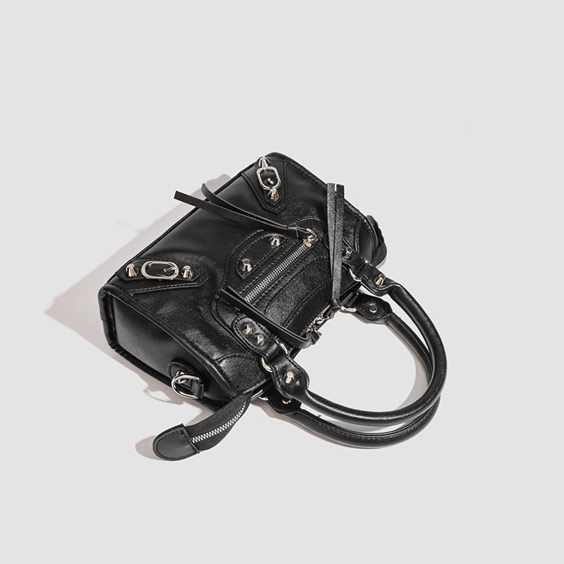 Women's mini handbag with decorative metal accents and removable shoulder strap