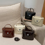 Ladies mini handbag in elegantly curved design with playful pendant