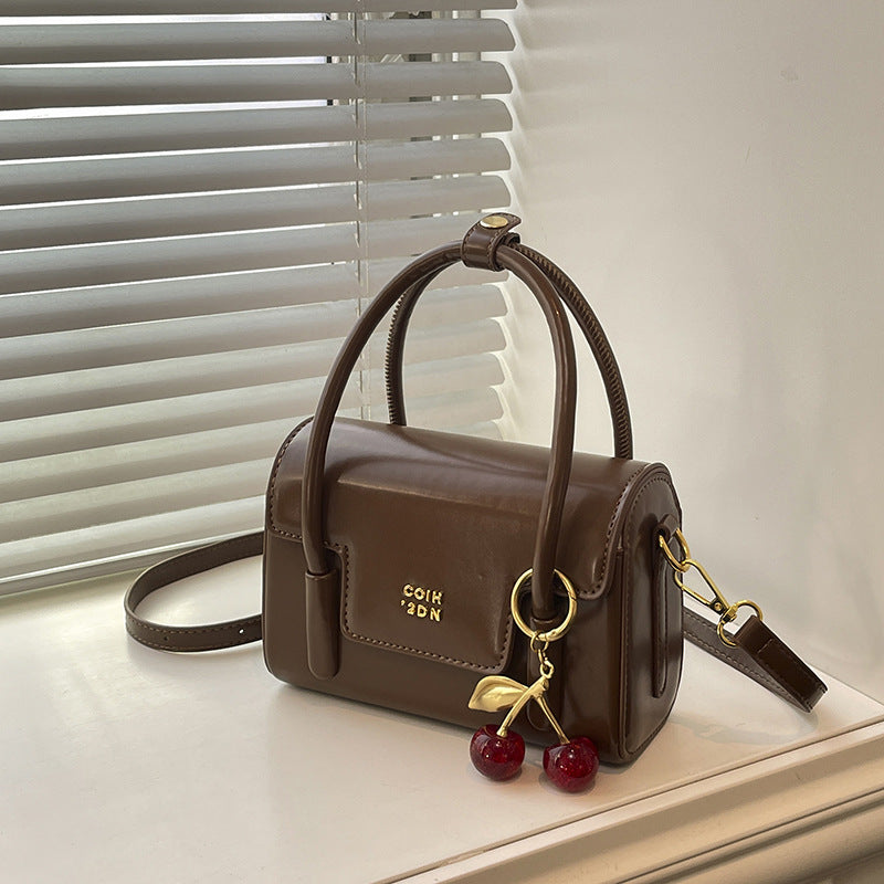 Women's mini handbag with elegant structure and charming pendant