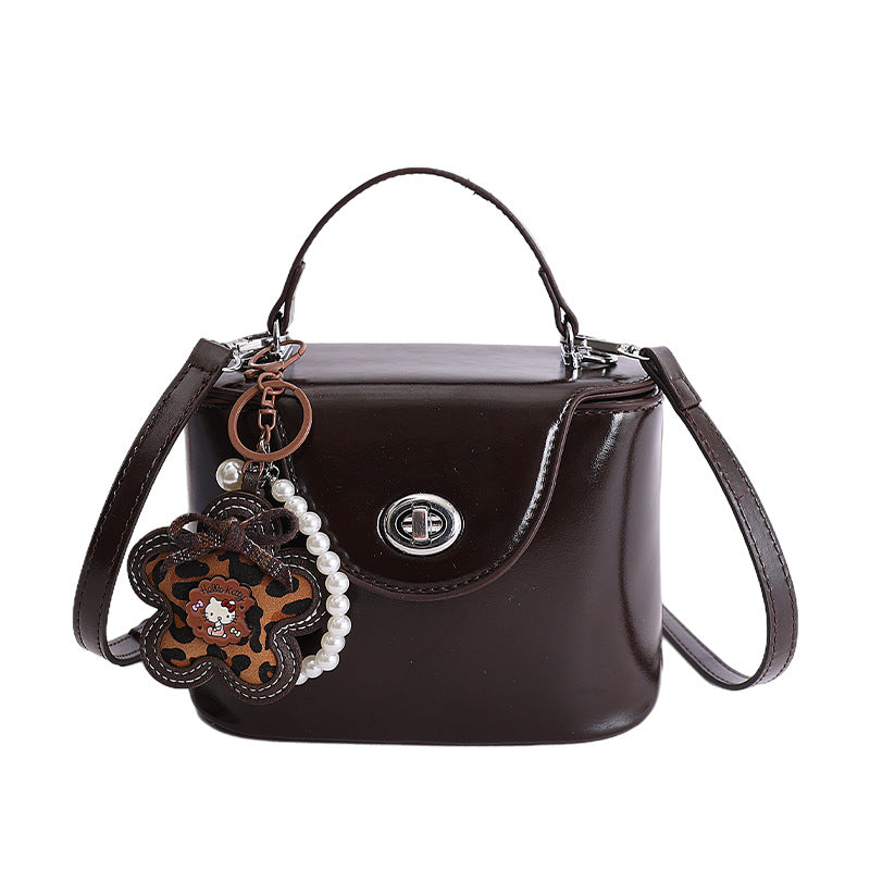 Ladies mini handbag in elegantly curved design with playful pendant