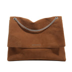 Women's clutch bag made of shiny synthetic leather with decorative chain strap