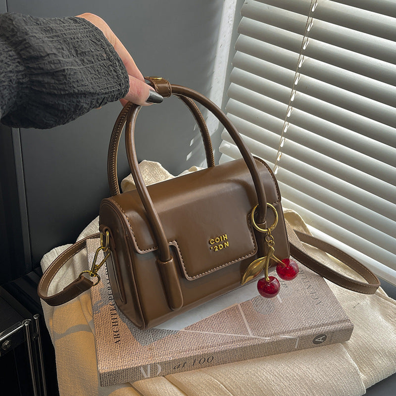 Women's mini handbag with elegant structure and charming pendant
