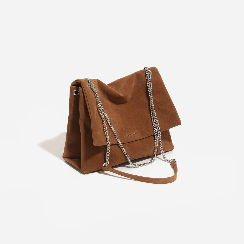 Women's clutch bag made of shiny synthetic leather with decorative chain strap