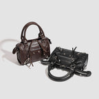 Women's mini handbag with decorative metal accents and removable shoulder strap