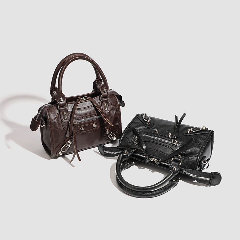 Women's mini handbag with decorative metal accents and removable shoulder strap
