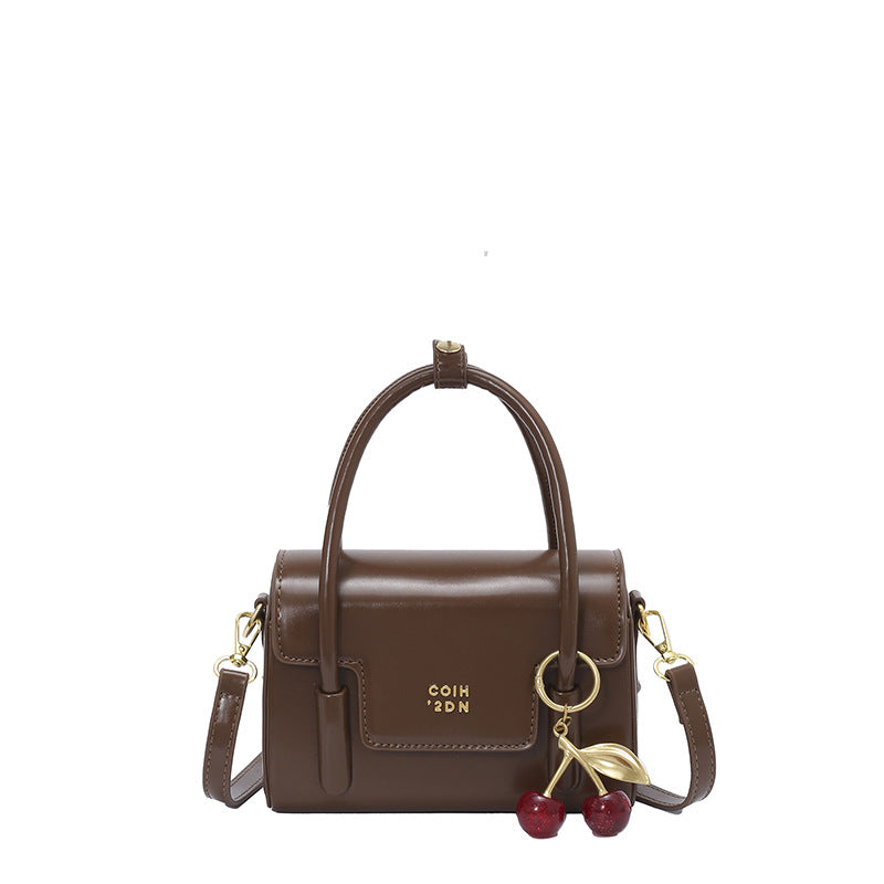 Women's mini handbag with elegant structure and charming pendant