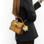 Women’s mini handbag with decorative braided pattern and playful pendant