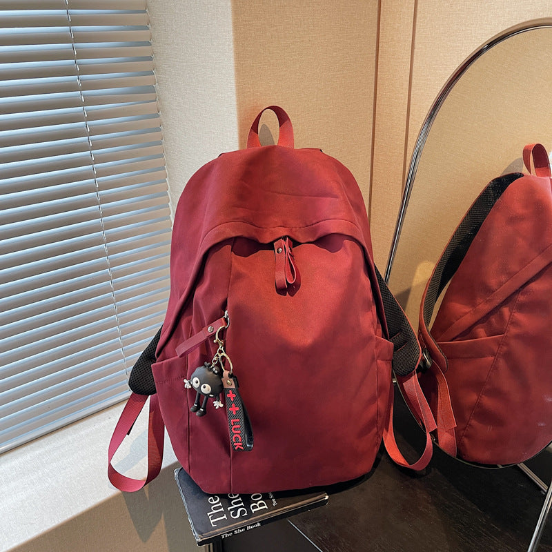 Fashionable backpack with practical design and decorative pendant