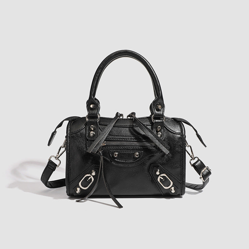 Women's mini handbag with decorative metal accents and removable shoulder strap