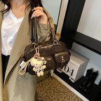 Elegant Handbag with Playful Charms and Multiple Compartments
