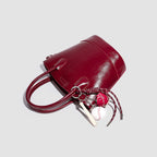 Women's mini bag with shiny surface and playful pendant