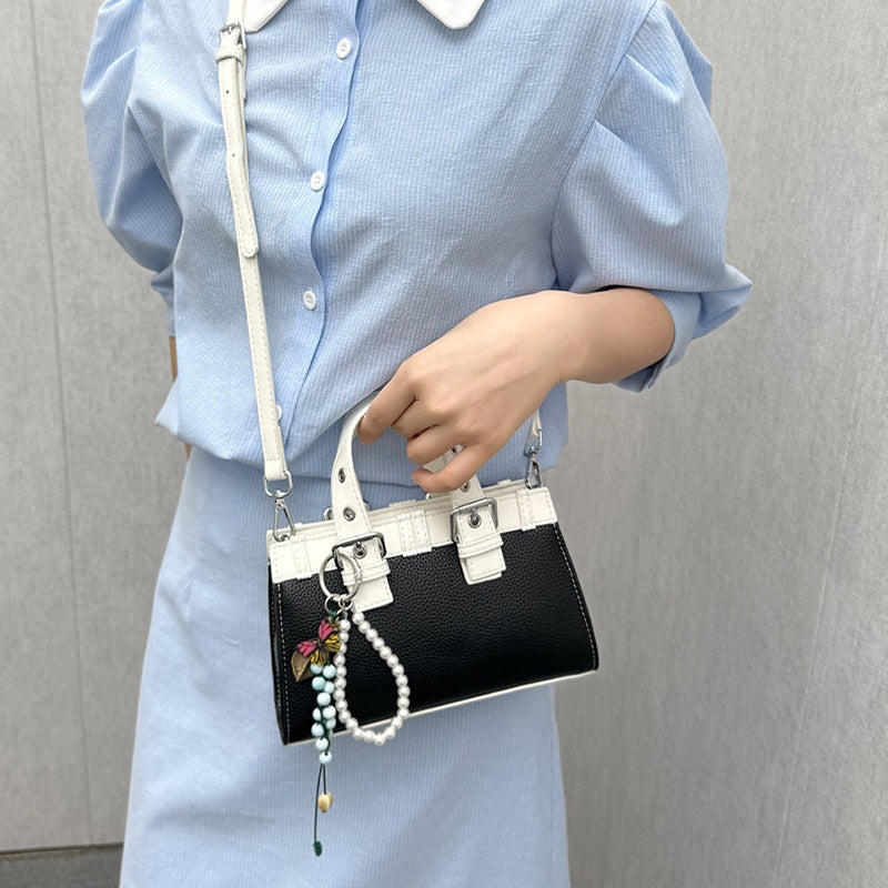 Women's mini handbag with playful pendant and elegant design