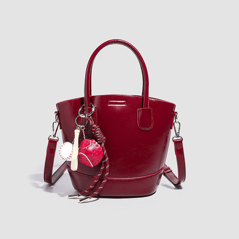 Women's mini bag with shiny surface and playful pendant