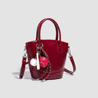 Women's mini bag with shiny surface and playful pendant
