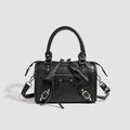 Women's mini handbag with decorative metal accents and removable shoulder strap