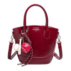 Women's mini bag with shiny surface and playful pendant