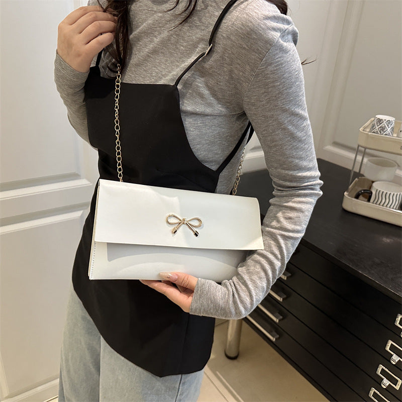 Women's elegant clutch in minimalist design with golden accents