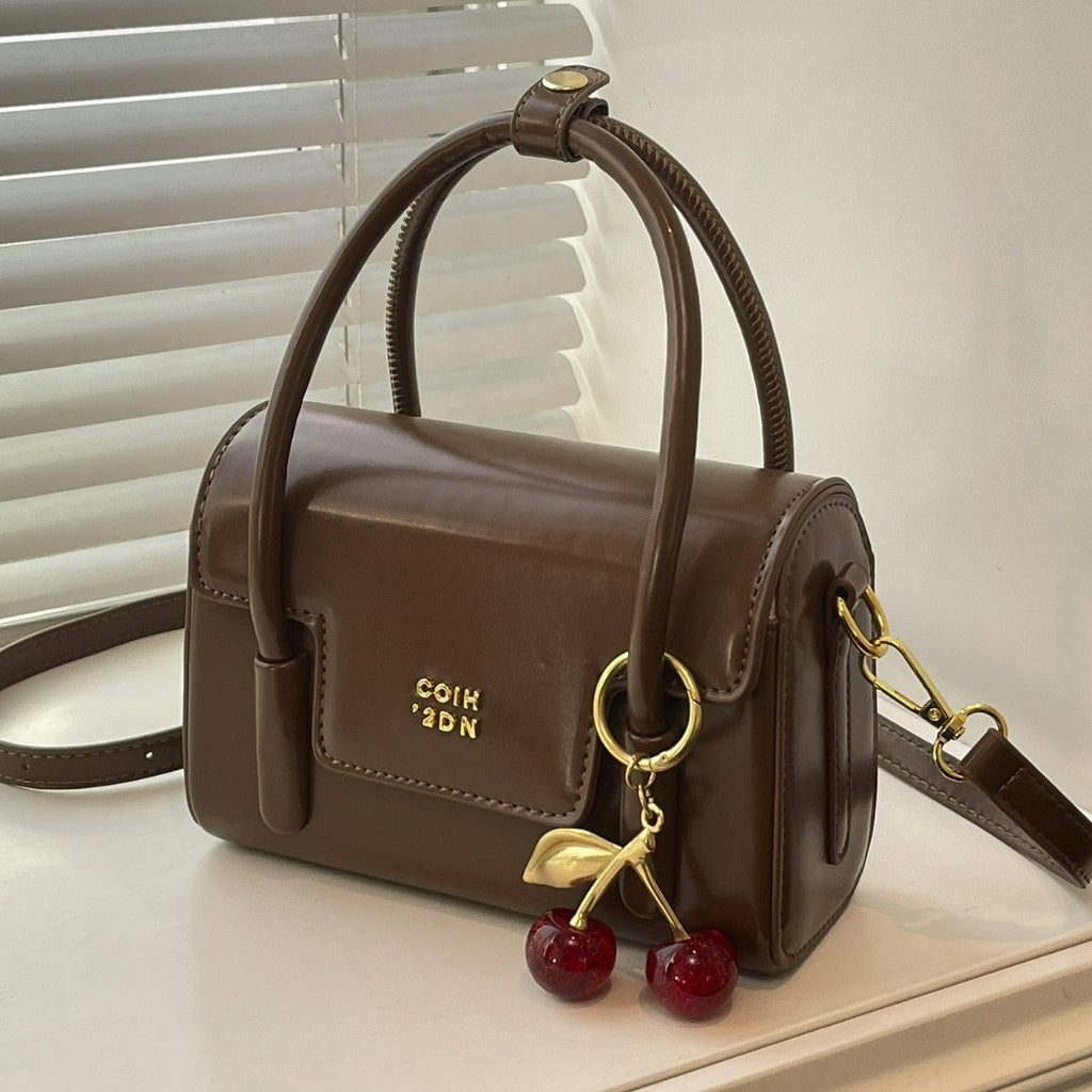 Women's mini handbag with elegant structure and charming pendant