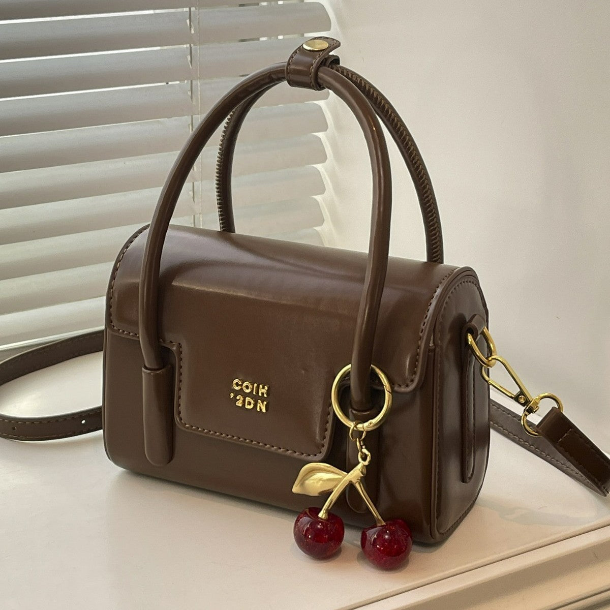 Women's mini handbag with elegant structure and charming pendant