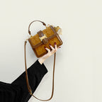 Women’s mini handbag with decorative braided pattern and playful pendant