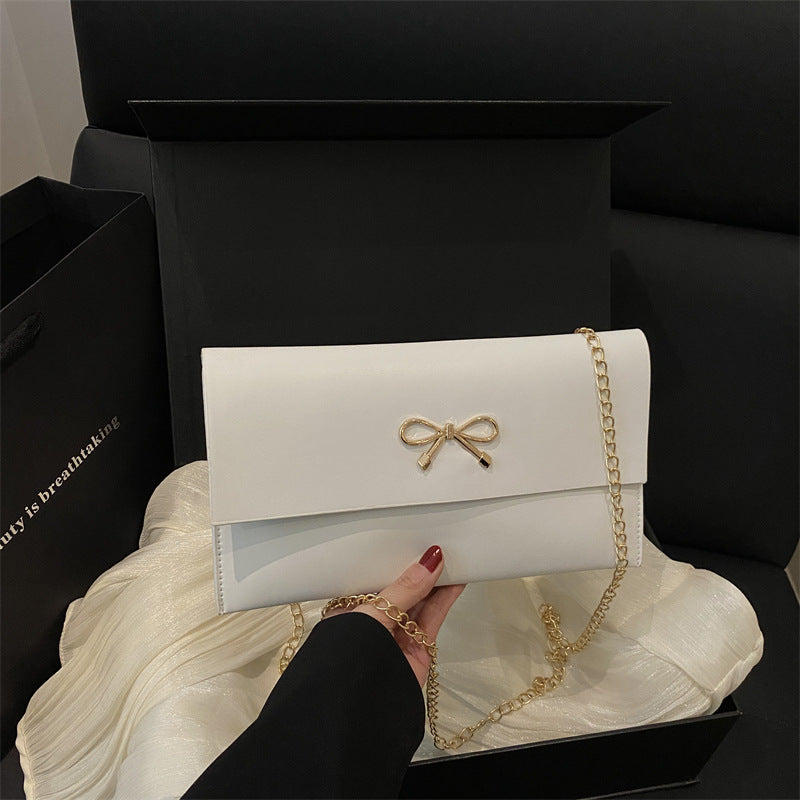 Women's elegant clutch in minimalist design with golden accents