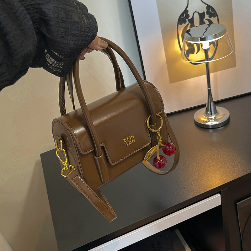 Women's mini handbag with elegant structure and charming pendant