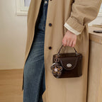 Ladies mini handbag in elegantly curved design with playful pendant
