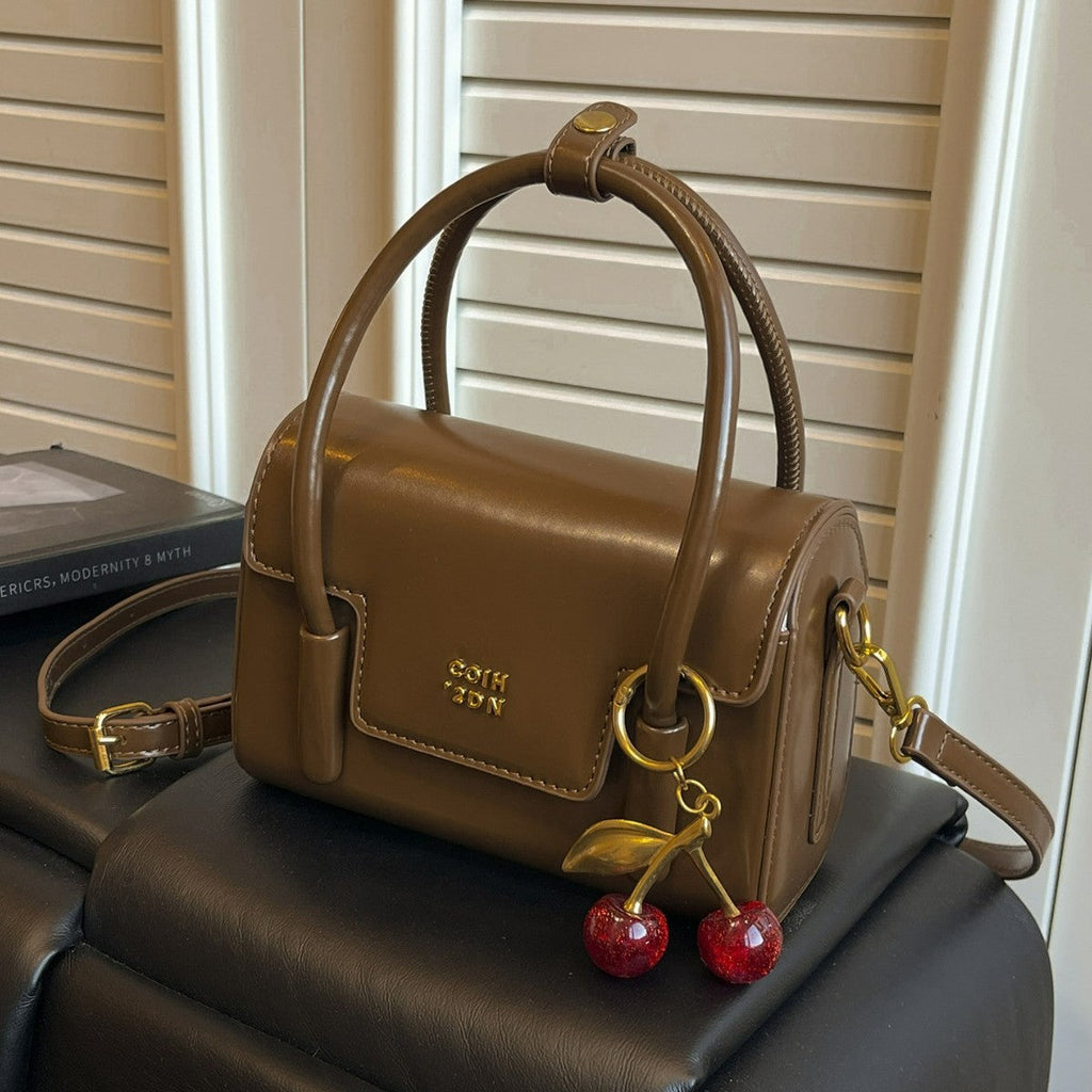 Women's mini handbag with elegant structure and charming pendant